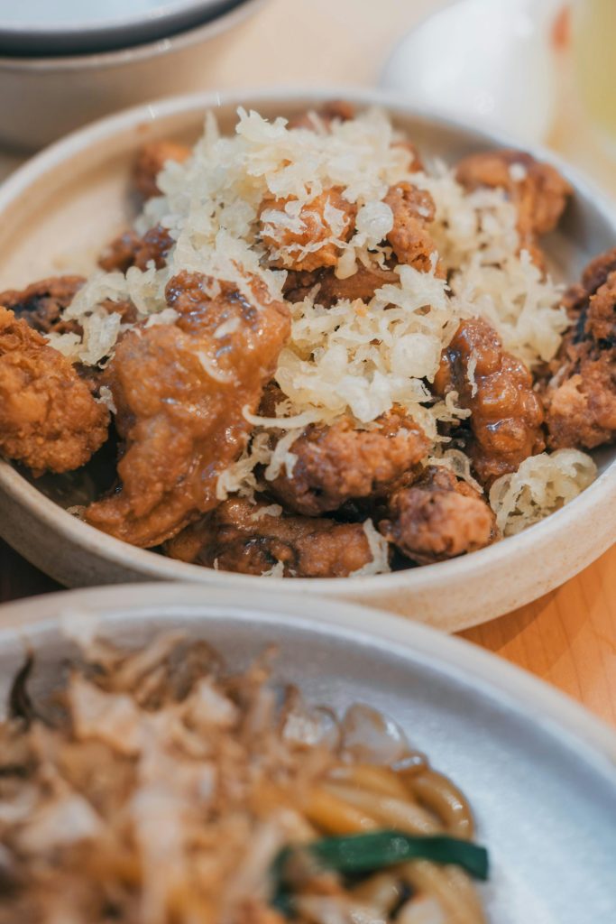 Delicious crispy fried chicken garnished with shredded topping, perfect for a savory meal.